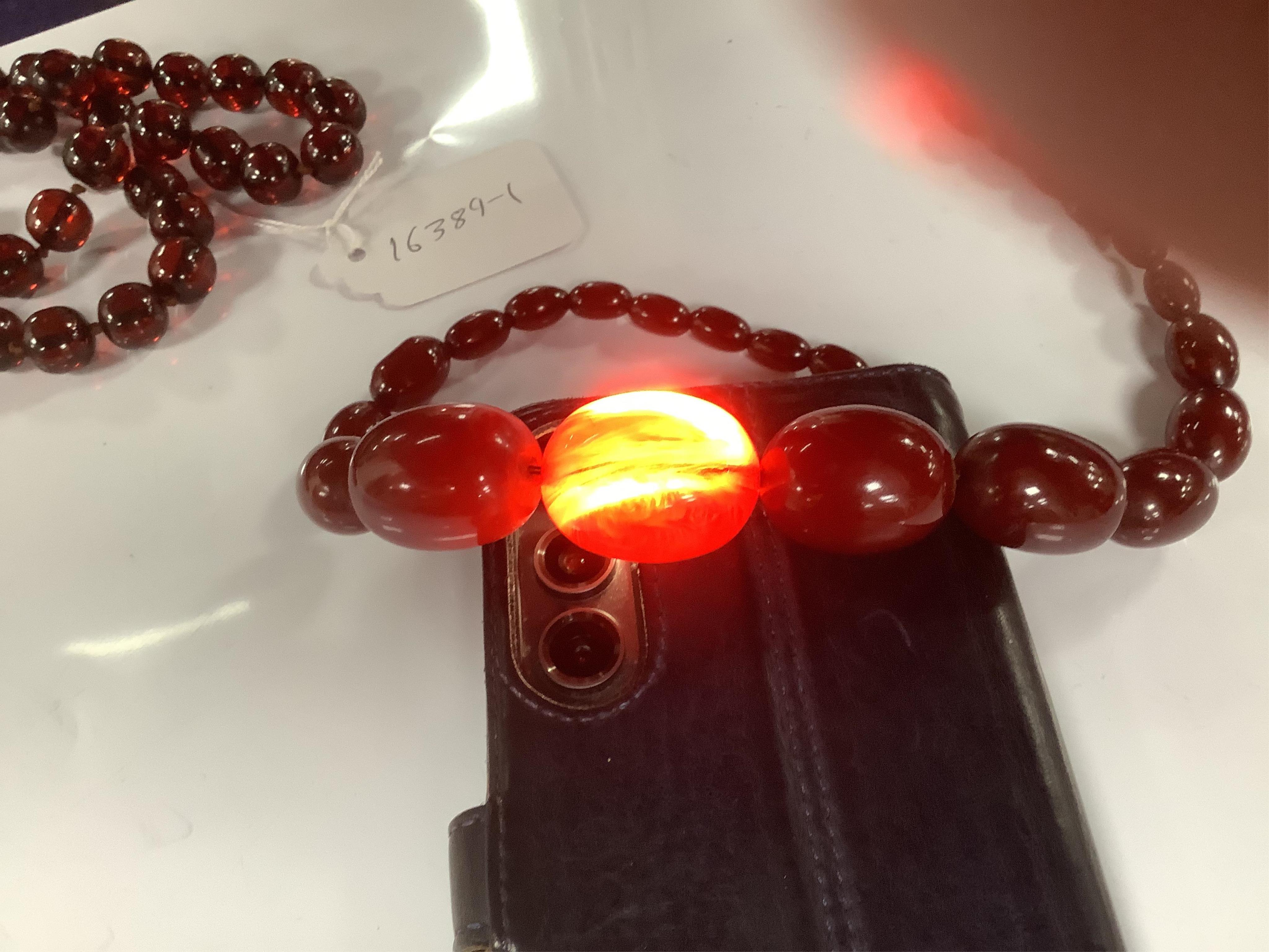 Two single strand simulated cherry amber bead necklaces, including one graduated string, 38cm, gross weight 173 grams. Condition - fair